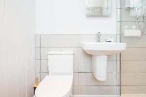 une salle de bain blanche avec toilettes et lavabo dans l'établissement Small Cottage, à Haverfordwest 21 autres photos