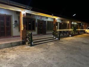 a building with lights on the side of it at night at Happy Hotel in Vang Vieng
