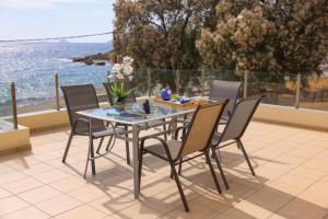 a table and chairs on a patio with a view of the ocean at KomiVillas in Kómi