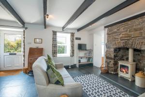 ein Wohnzimmer mit Couch und Kamin in der Unterkunft Bwthyn Beatties in Haverfordwest