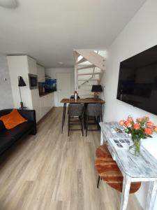 a living room with a table with a vase of flowers at Hello Noordwijk - Familiehuis Quarles van Uffordstraat 77 in Noordwijk aan Zee