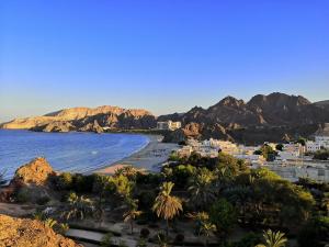 马斯喀特The Blue Gate 1的享有海滩美景,背景为群山