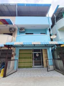 a view of the front of a blue house with a gate at Sawasdee Home in Betong