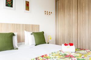 una camera da letto con un grande letto bianco con cuscini verdi di Vista de Cinema Praia da Armação dos Búzios a Búzios