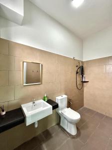 a bathroom with a toilet and a sink at New Cozy 4-bedroom Terrace Home in Kampong Tanjong Laboh