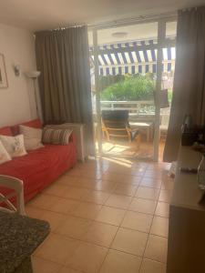 ein Wohnzimmer mit einer roten Couch und einer Glasschiebetür in der Unterkunft Jumbo apartment in San Bartolomé de Tirajana