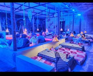 a group of people sitting in a room with beds at River Bay Hampi in Hampi