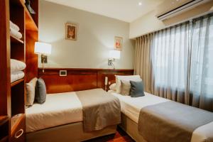 a hotel room with two beds and a window at Hotel Club del Golf in Mar del Plata +152 photos