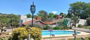a house with a swimming pool in a yard at Casa y cabaña de Gachy in Villa Carlos Paz
