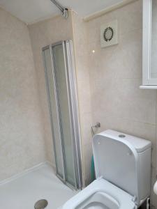 Un baño con inodoro blanco y ducha. en Near Queens hospital ensuite room, en Nottingham