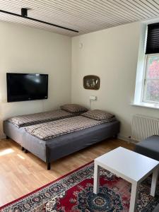 a bedroom with a bed and a flat screen tv at Lunderskov og tæt på Legoland og Hansenberg veterinær in Lunderskov