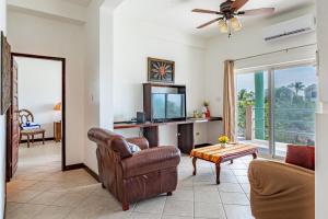 Una sala de estar con un sofá y un televisor. en Suite A202 @ Mara Laguna *Gold Standard Certified, en San Pedro