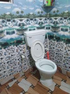 a bathroom with a toilet with a painting on the wall at Shiv sakti homestay in kolkata