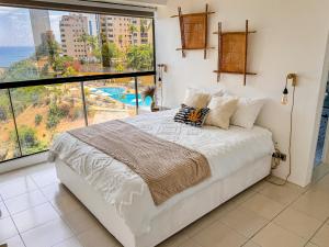 Llit o llits en una habitació de Beach front 9 min to airport DosLocosDeViaje