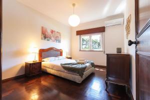 une chambre avec un lit et une fenêtre dans l'établissement Vita Portucale ! Sintra Retreat Villa with Pool, à Sintra