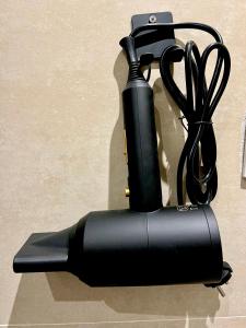 マドリードにあるAlbergue Miguel Ángelの黒い電気式ヘアドライヤー(テーブルに座って使用)