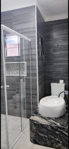 a bathroom with a shower and a toilet and a sink at Suite S3 in Bertioga +5 photos