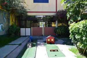 een tuin met een speelgoedhuis in het gras bij Kibo Hotel in Ayacucho