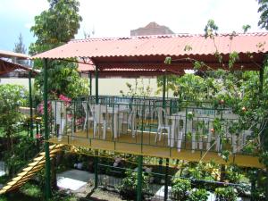 een terras met tafels en stoelen in een tuin bij Kibo Hotel in Ayacucho