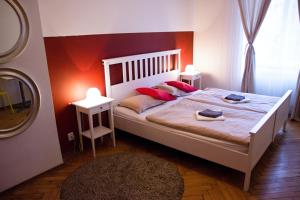 a bedroom with a large white bed with red walls at Budget Apartment in Prague