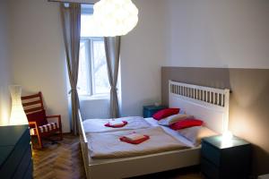 um quarto com uma cama com almofadas vermelhas em Budget Apartment em Praga