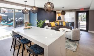 a kitchen and living room with a white counter and chairs at Redondo Beach 1BR w Pool Gym nr Beach LAX-396 in Redondo Beach