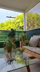 a living room with a glass table and plants at Coeur de Rhoda in Saint-François