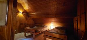 une chambre avec deux lits dans une cabane en bois dans l'établissement Chalet les Alpages vue panoramique sur le lac Léman, à Thollon-les-Mémises