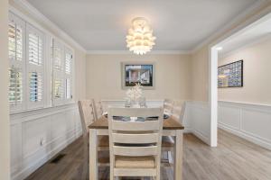 Minutes to Craigville Beach Private Patio and Backyard في بارنستابل: غرفة طعام مع طاولة وكراسي وثريا +18 صورة