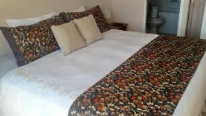 a white bed with a flowered blanket on it at Santiago Neighborhood in Santiago