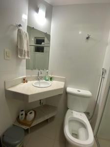 a white bathroom with a toilet and a sink at Quarto em apartamento in Ouro Preto