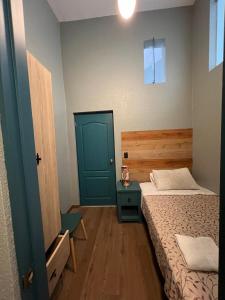 a small bedroom with a bed and a blue door at Hospedaje Milan in Lima