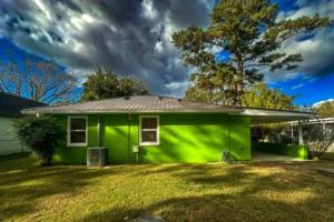 a green house with a gray roof on a yard at Kitchen, Laundry & Fenced Yard in New Bern