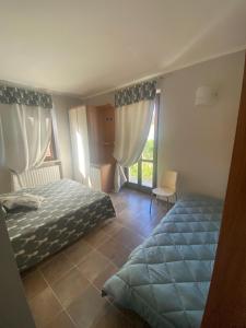 弗拉博萨索普拉纳Appartamento Frabosa的有两张床和一扇窗户的卧室 更多2张照片