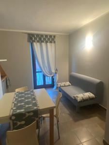 a living room with a couch and a table and a window at Appartamento Frabosa in Frabosa Soprana +2 photos