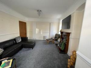 a living room with a black couch and a flat screen tv at The Brooklyn in Kendal