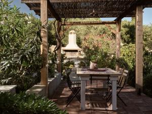 a table and chairs under a pergola with a bell at Strofilia Stone Residences in Volímai