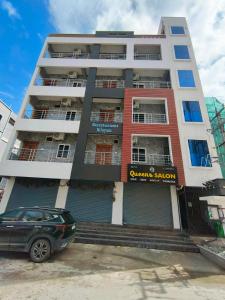 a building with a car parked in front of it at Servostay Newly Launched Luxury Fully Furnished 1 BHK Flats in Tirupati