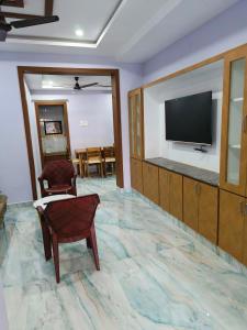 a living room with a television and a chair at Servostay Newly Launched Luxury Fully Furnished 1 BHK Flats in Tirupati