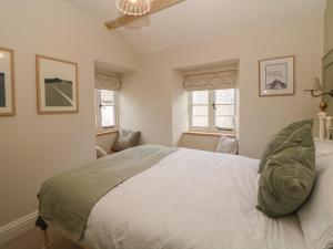 a bedroom with a large bed in a room with windows at The Cottage on the Island in Castleton