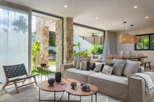 ein Wohnzimmer mit Sofa und Tisch in der Unterkunft Stylish 5BR Villa for Bachelorette Aldea Zama in Tulum