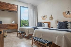 ein Schlafzimmer mit zwei Betten und einem großen Fenster in der Unterkunft Stylish 5BR Villa for Bachelorette Aldea Zama in Tulum + 19 Fotos