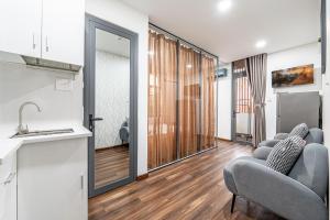 a kitchen and living room with two chairs and a sink at Lotus Lalala Inn Hotel in Ho Chi Minh City