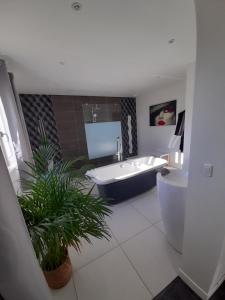 a bathroom with a tub and a toilet and a sink at Chambres 2 caps in Ambleteuse