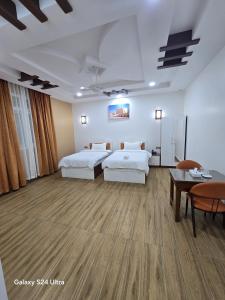 a hotel room with two beds and a table at Dar Al Salaam Hospitality House in Nizwa +30 photos