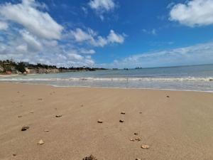 a beach with a few footprints in the sand at Pousada Odoyá Beach - Quádrupla in Conde +5 photos