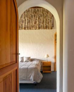 a bedroom with a bed and a table with a lamp at Casa Arrayán in San Carlos de Bariloche