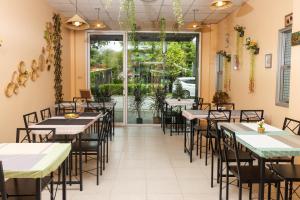 a dining room with tables and chairs and a large window at Taw Win Place in Chiang Mai