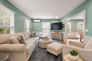 a living room with a couch and a tv at Minutes to Oceanside beaches Private Deck and Backyard in Dennis