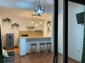 a kitchen with two bar stools at a counter at LU'UM Master Suites in Taxco de Alarcón